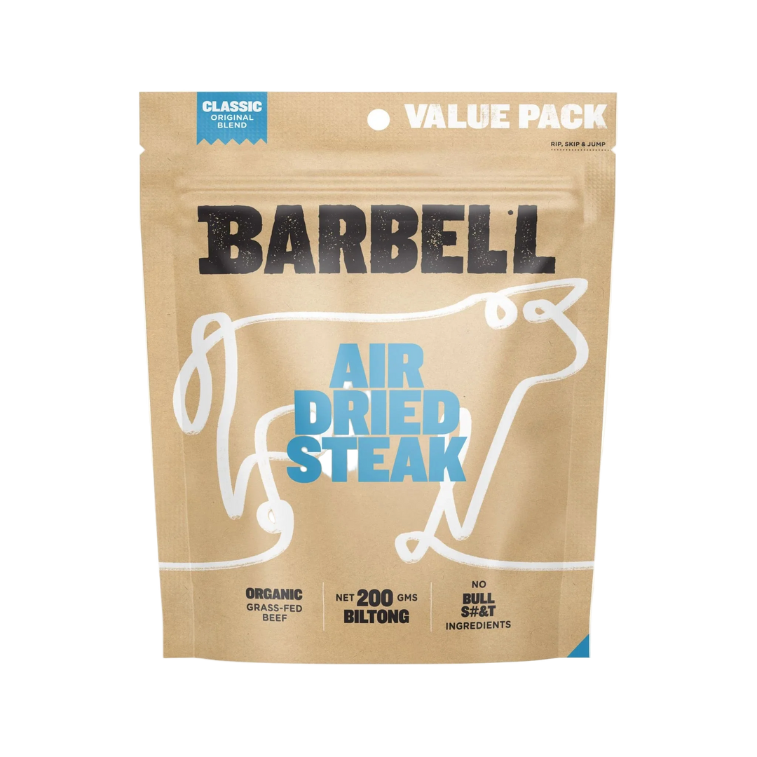 A brown resealable bag labeled Barbell Classic Air Dried Steak Organic Grass Fed Beef, featuring a cow outline. The packaging highlights 200g protein-rich biltong with no bullsh*t ingredients.