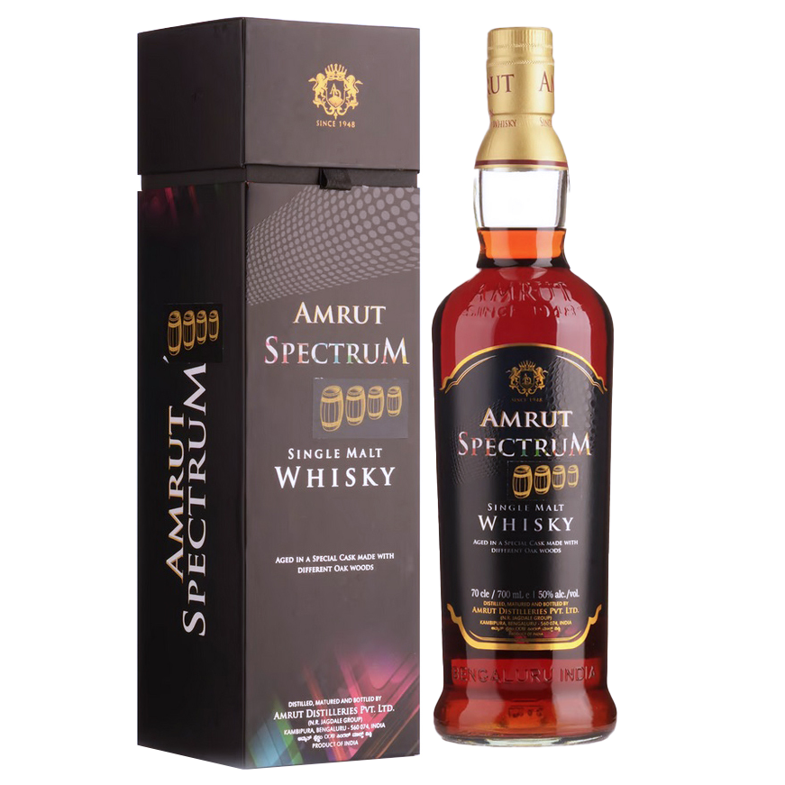 A bottle of Amrut Spectrum Indian Single Malt Whisky stands beside its black and gold box. The label highlights its unique maturation in a special cask crafted from diverse oak woods.