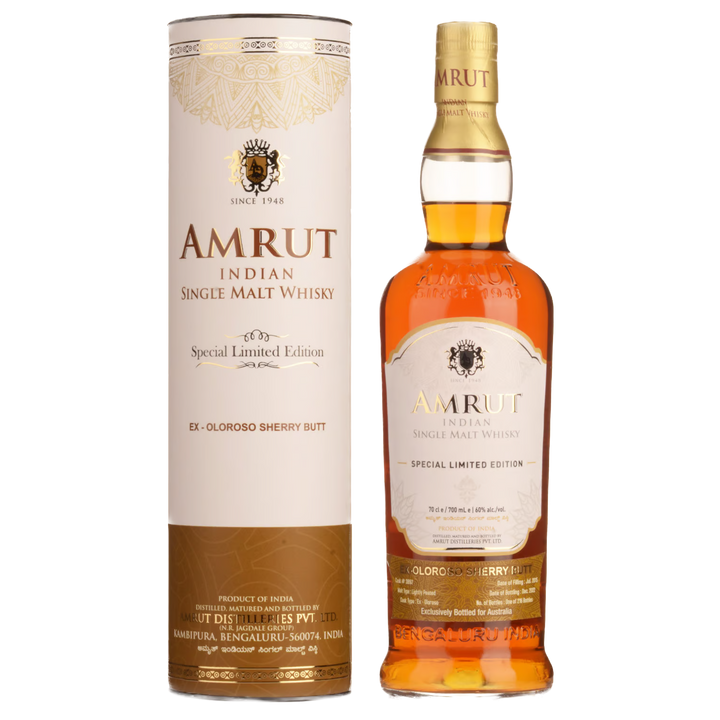 A bottle of Amrut Oloroso Cask #3897 Indian Single Malt Whisky stands beside its matching cylindrical box, both adorned with gold and brown details emphasizing its sherry cask-aged character.