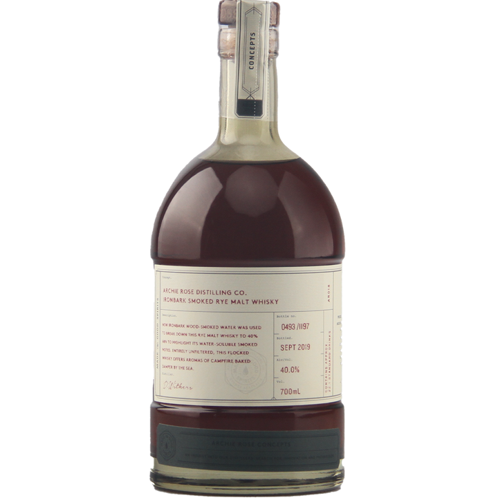 A limited-edition 700ml bottle of Archie Rose Ironbark Smoked Rye Malt Whisky features a cream label, handwritten details, wax-sealed cap, and contains dark amber spirit at 40% ABV.