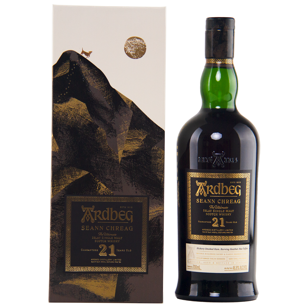 A bottle of Ardbeg 21 Year Old Seann Chreag Single Malt Scotch Whisky stands beside its decorative box, adorned with an abstract mountain design and gold accents. The label highlights the whisky’s name and limited 21-year age statement.