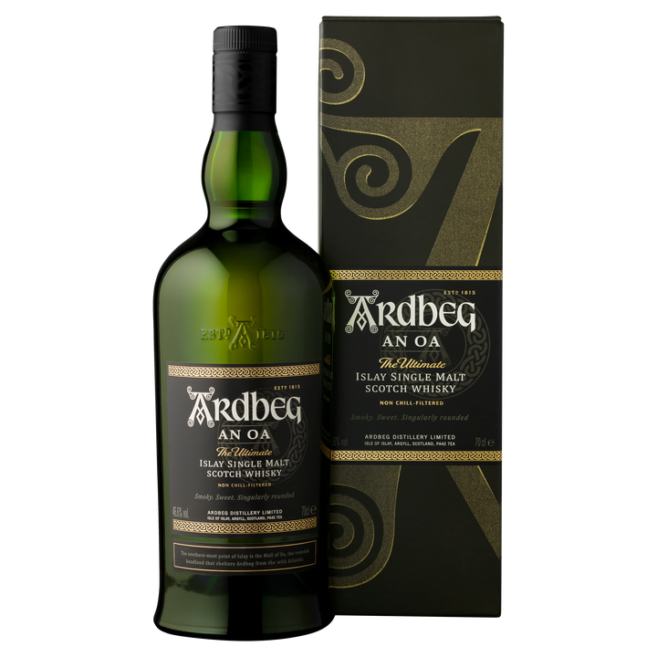 A bottle of Ardbeg An Oa Single Malt Scotch Whisky stands beside its black and gold box, both adorned with elegant swirling patterns and detailed labels.