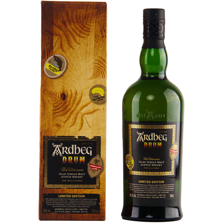 A bottle of Ardbeg Drum Single Malt Scotch Whisky, a limited edition peated Islay malt, is shown beside its wood-textured box, both adorned with gold and black labels featuring the iconic Ardbeg branding.