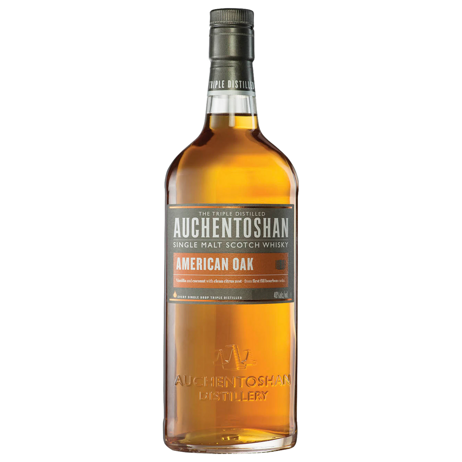 A tall, transparent bottle of Auchentoshan American Oak Single Malt Scotch Whisky shows the amber spirit inside and features a clear label with silver, white, and orange accents.