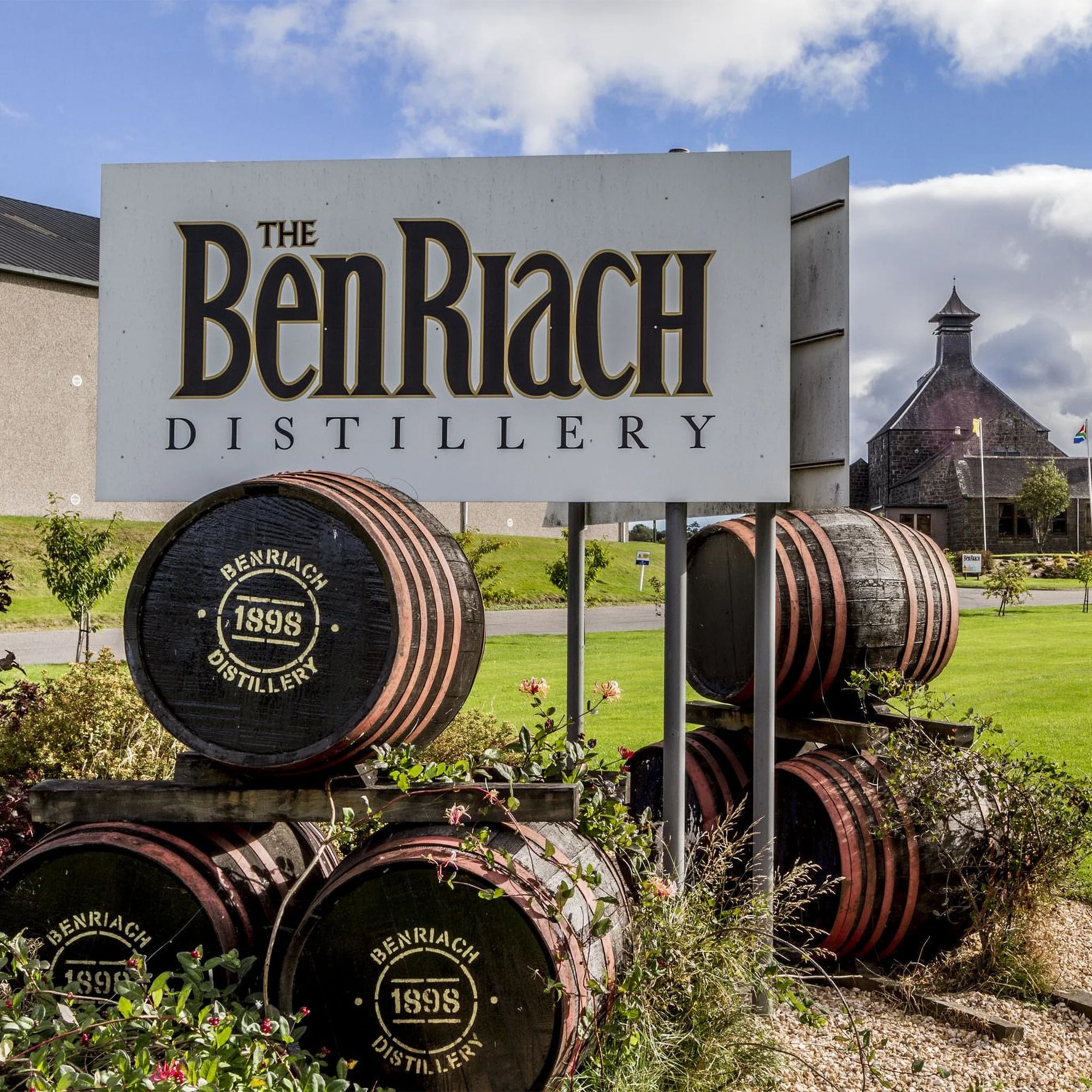 BenRiach Distillery sign with barrels in front on a sunny day