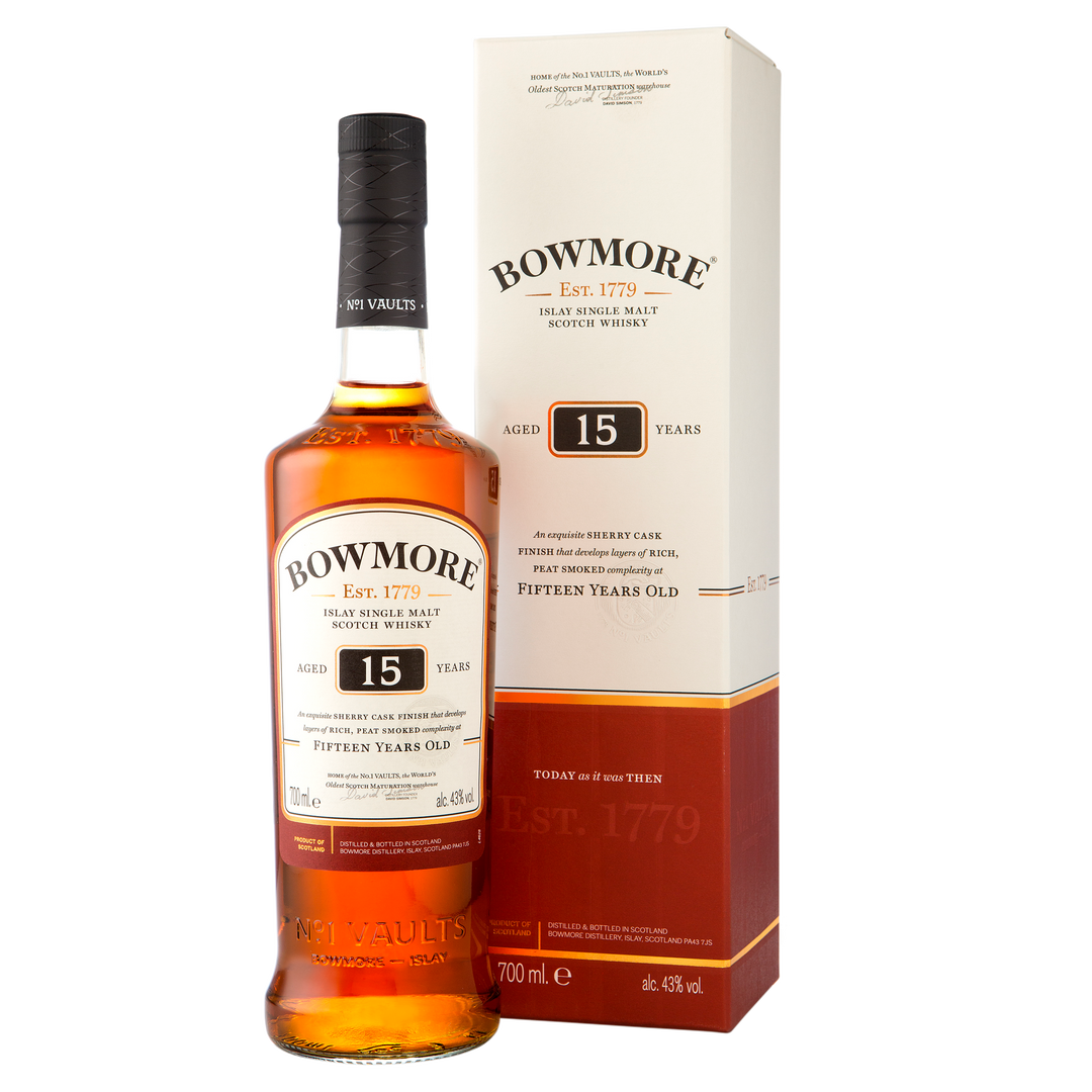 A bottle of Bowmore 15 Year Old Single Malt Scotch Whisky stands beside its matching cream-colored box with gold and brown accents, both featuring the brand name, age statement, and sherry cask whisky details.
