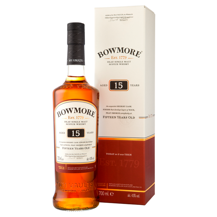 A bottle of Bowmore 15 Year Old Single Malt Scotch Whisky stands beside its matching cream-colored box with gold and brown accents, both featuring the brand name, age statement, and sherry cask whisky details.