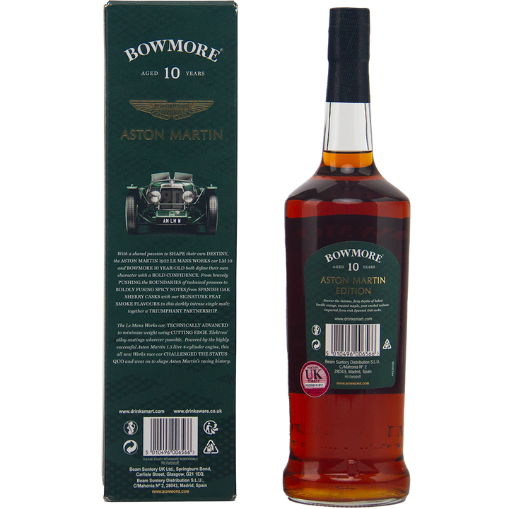 A bottle of Bowmore 10 Year Old Aston Martin Edition 1 Dark & Intense Single Malt Scotch Whisky is displayed beside its green box, decorated with a classic Aston Martin car image and gold branding.