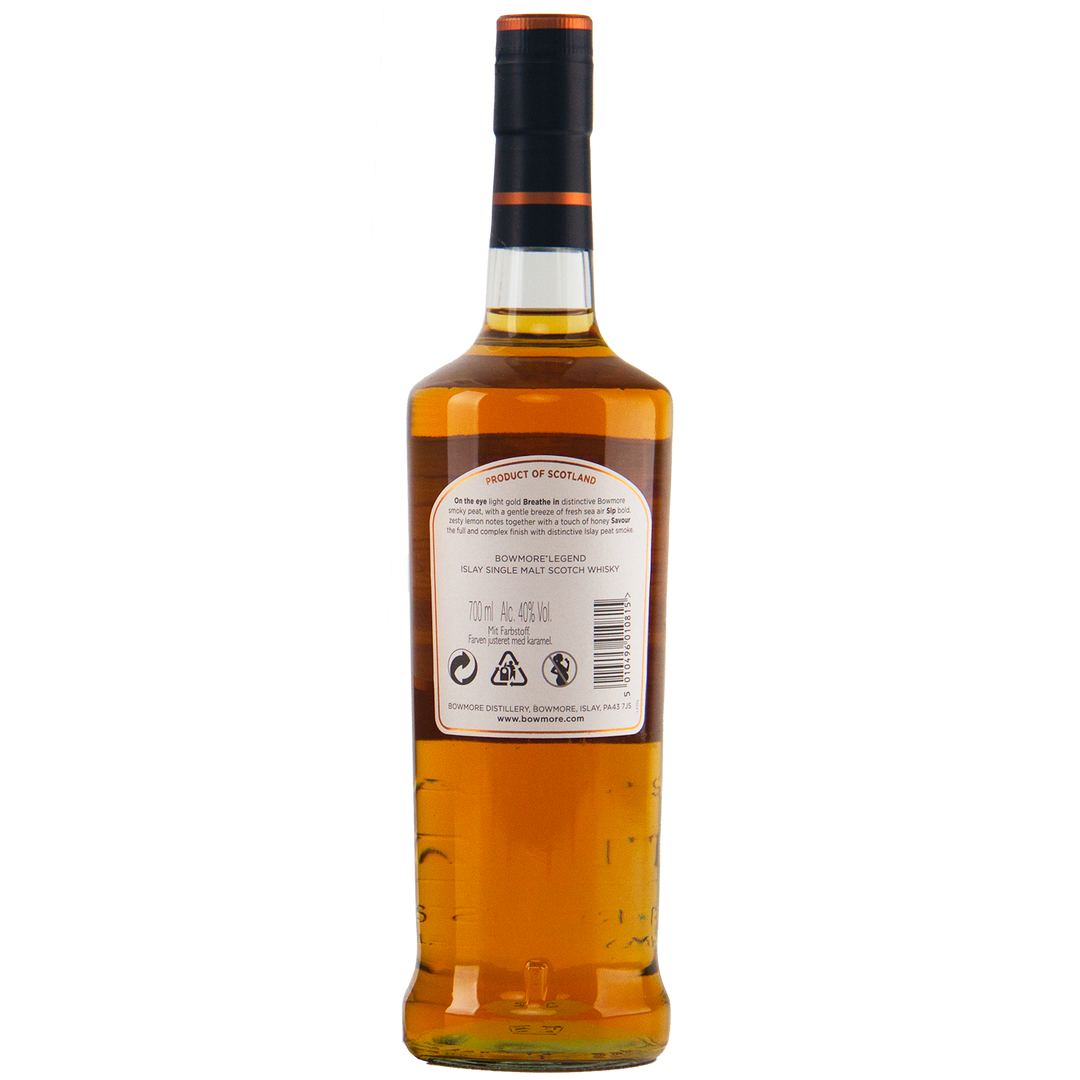 A bottle of Bowmore Legend Islay Single Malt Scotch Whisky is shown from the back on a plain white background, revealing amber peated whisky inside the clear glass and a white label with text and symbols.