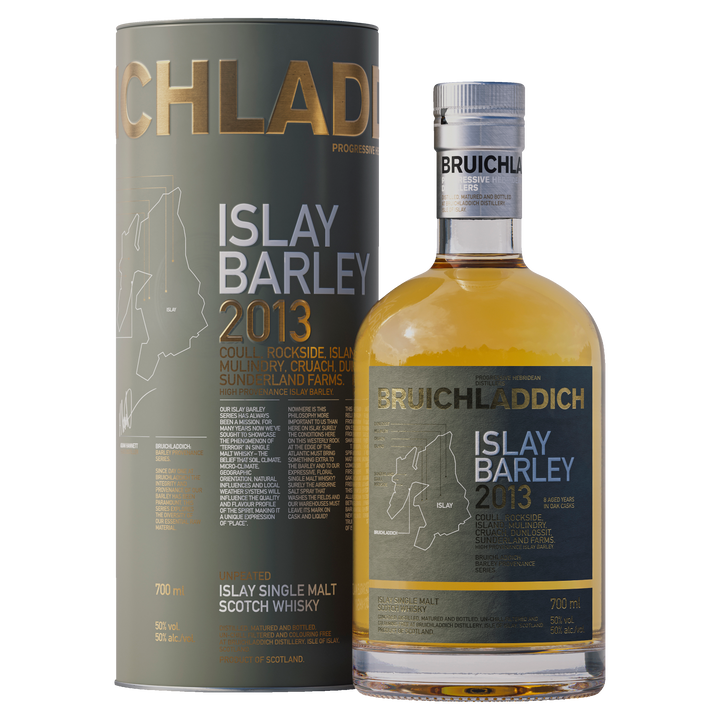 A bottle of Bruichladdich Islay Barley Single Malt Scotch Whisky stands beside its matching cylindrical box, both decorated with gold and white text, map outlines, and details about the whisky’s Islay origins and distillery.