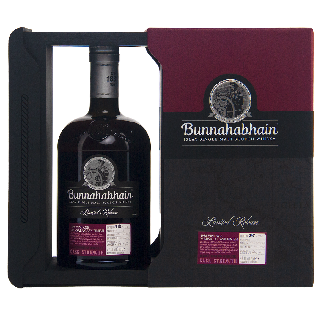 A bottle of Bunnahabhain 30 Year Old 1988 Vintage Islay Single Malt Scotch Whisky in dark glass, presented in a black and burgundy Limited Release Cask Strength box.