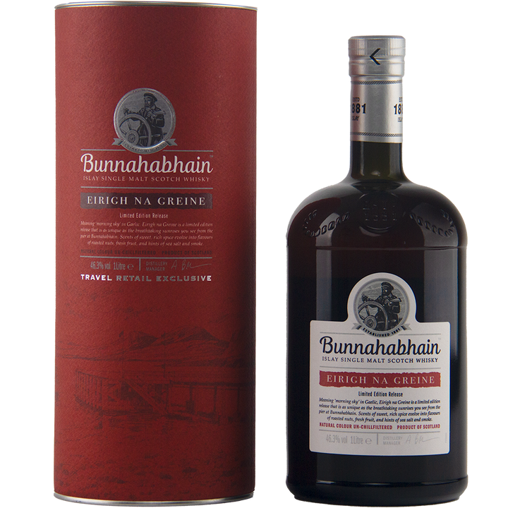 A bottle of Bunnahabhain Eirigh Na Greine single malt Scotch whisky, matured in red wine casks, stands next to its matching red cylindrical box, both featuring the brand’s logo and product info in white and black text.