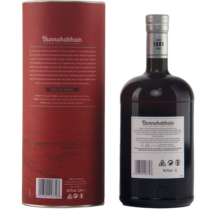 A dark bottle of Bunnahabhain Eirigh Na Greine single malt Scotch whisky with a black cap stands beside its cylinder. Both feature tasting notes, the year 1881, and details on its red wine cask maturation on their detailed labels.