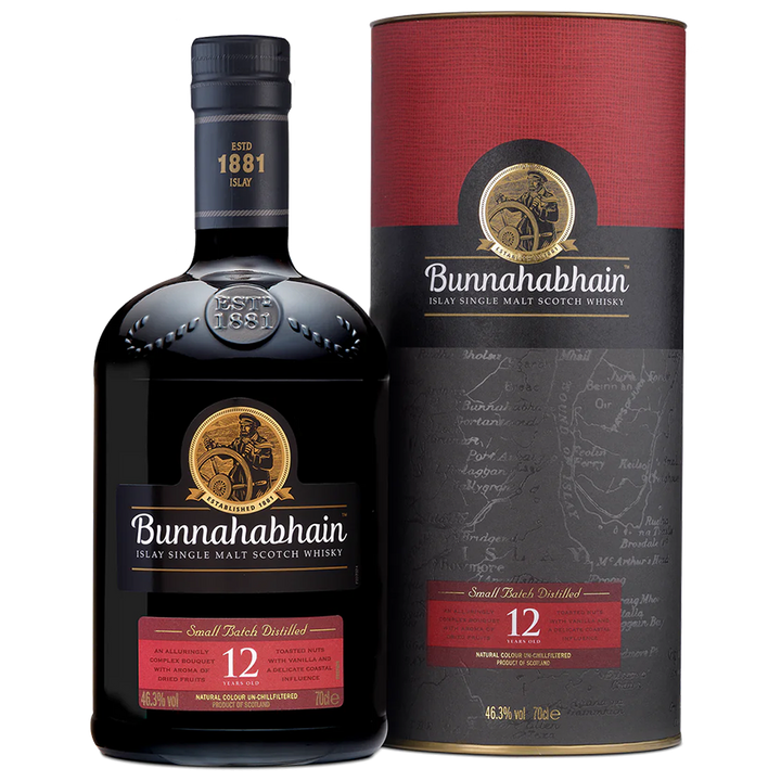 A bottle of Bunnahabhain 12 Year Old Single Malt Scotch Whisky stands beside its matching box, both with black and red labels featuring gold accents and the iconic sailor logo, showcasing this classic Islay single malt.