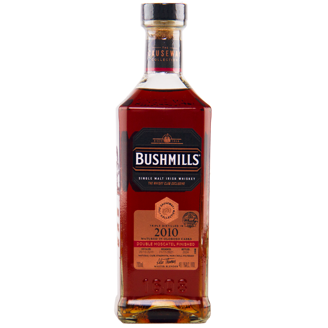 Bushmills 2010 Double Moscatel Cask Single Malt whisky from the Causeway Collection comes in a rectangular bottle with a black label, gold and copper accents, and a copper nameplate highlighting its double moscatel finish.