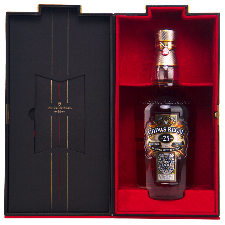 A bottle of Chivas Regal 25 Year Old Blended Scotch Whisky is showcased in an open presentation box lined with black and red velvet, featuring gold lettering and decorative accents.