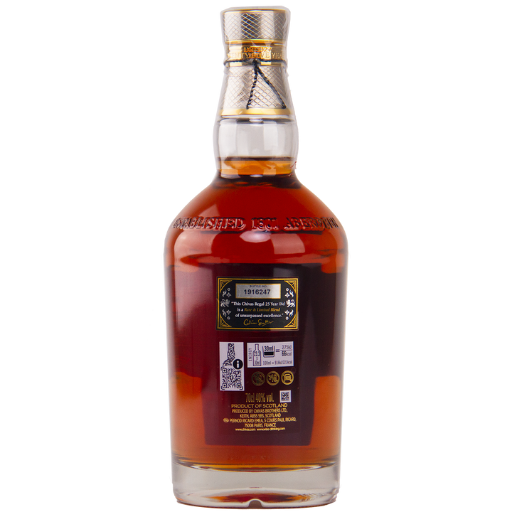 A clear glass bottle of Chivas Regal 25 Year Old Blended Scotch Whisky filled with dark brown liquor, sealed with a gold and silver cap. The back label shows a serial number, barcodes, product details, and embossed text near the neck.