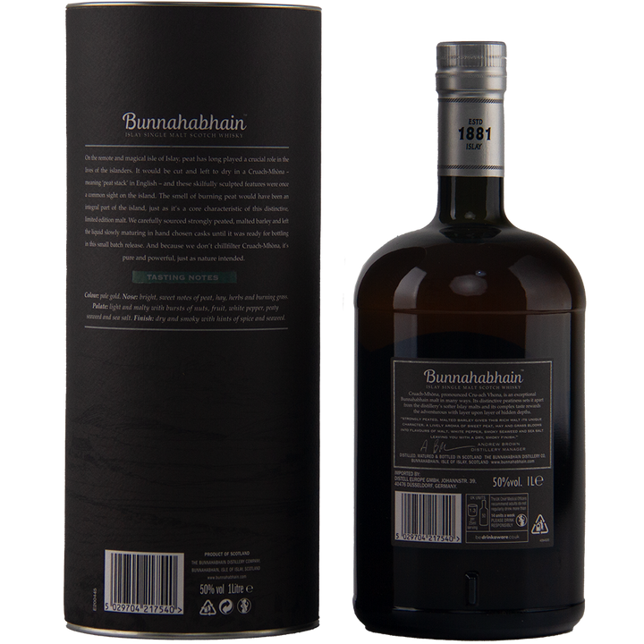 A bottle of Bunnahabhain Cruach Mhona Single Malt Scotch Whisky and its black cylindrical packaging are shown from the back, both featuring detailed text and a minimalist, elegant Islay design.