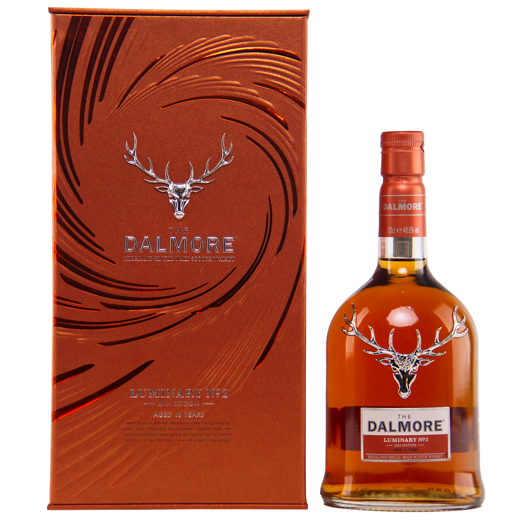 A bottle of The Dalmore Luminary No. 2 16 Year Old Single Malt Scotch Whisky stands beside its matching metallic orange box, both adorned with the silver stag logo and embossed patterns—capturing the essence of Dalmore’s luxury.