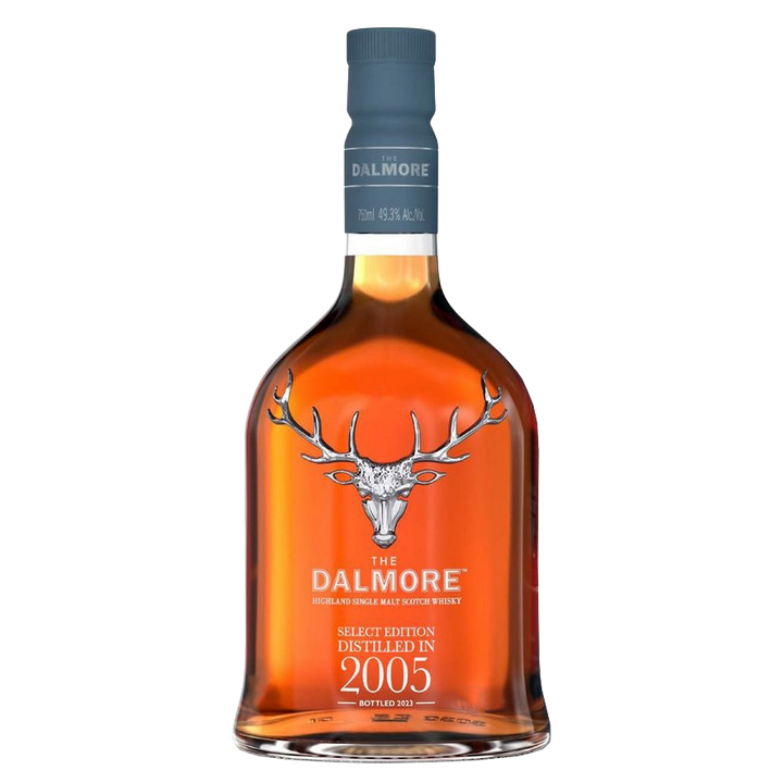 A bottle of The Dalmore 18 Year Old 2005 Vintage Single Malt Whisky features a stag logo, blue cap, rich amber liquid, and bears “Distilled in 2005” and “Bottled 2023,” crafted as a sherry cask Highland Scotch.