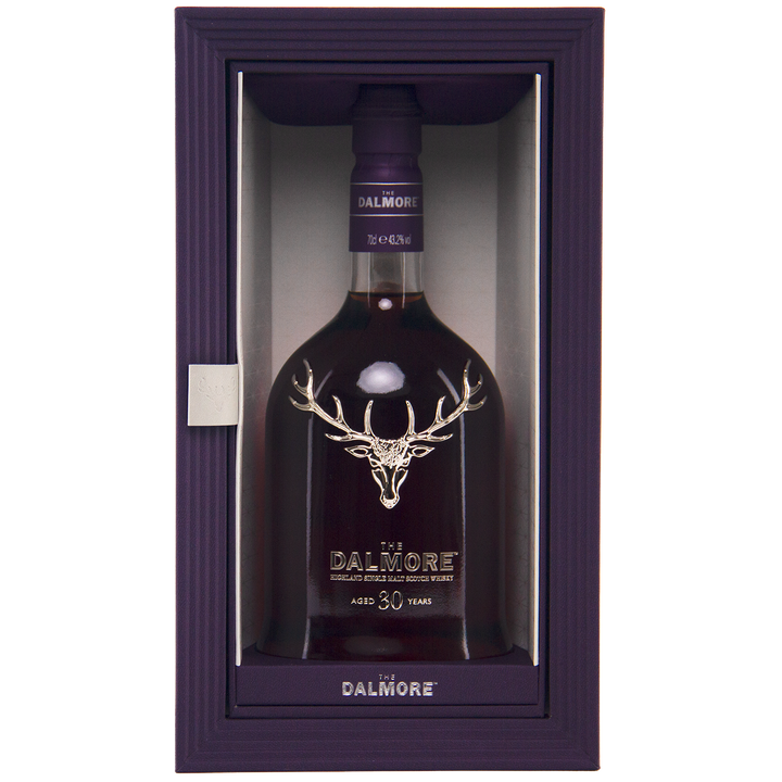 A bottle of The Dalmore 30 Year Old Single Malt Scotch with a silver stag logo, presented in a purple box featuring a clear front panel.
