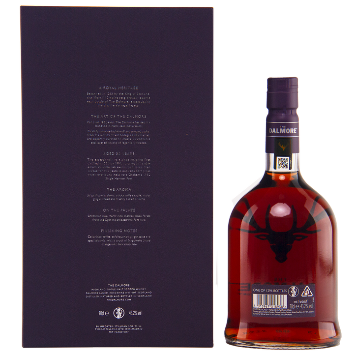 A bottle of The Dalmore 30 Year Old Single Malt Scotch with a dark cap and stag logo stands next to its tall, dark box with white back text—a luxurious whisky display.