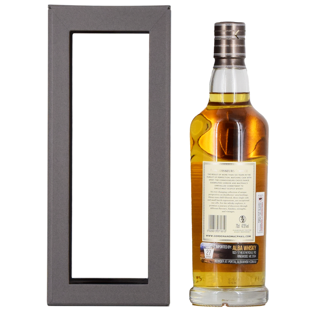 A bottle of Gordon & MacPhail Tomatin 1990 28 Year Old Single Malt Scotch Whisky 700ml with a silver cap stands beside a black gift box with a large transparent window, showing the whisky label and the back of the box.