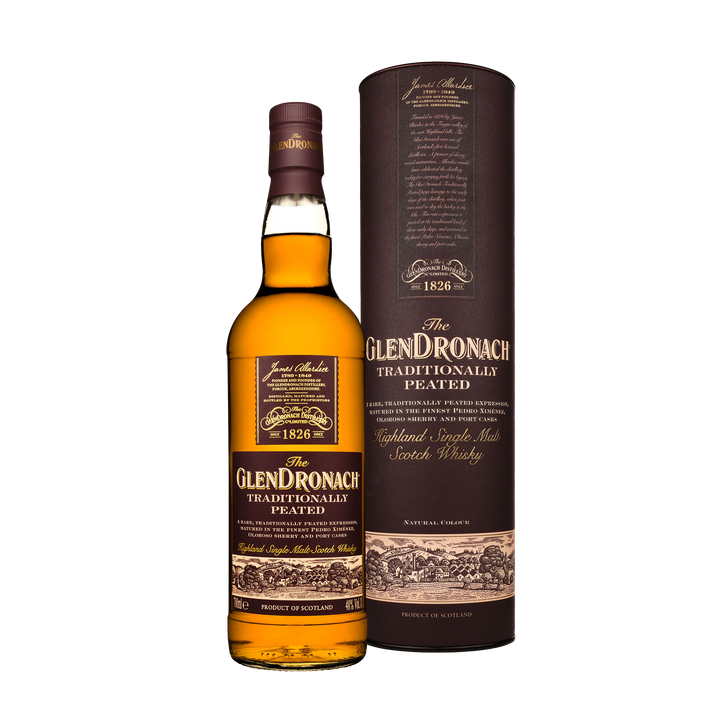 A bottle of Glendronach Traditionally Peated Single Malt Scotch Whisky stands next to its matching brown cylindrical packaging, both adorned with gold and white text and decorative elements that highlight its sherry cask heritage.