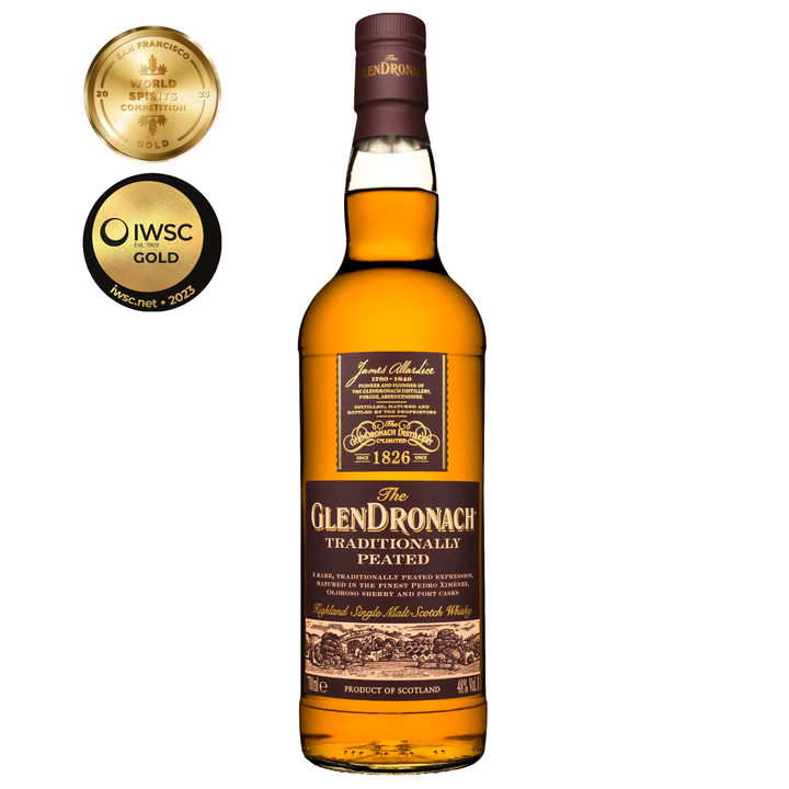 A bottle of Glendronach Traditionally Peated Single Malt Scotch Whisky stands upright against a white background, with two gold award medals on the left highlighting its spirits competition achievements.