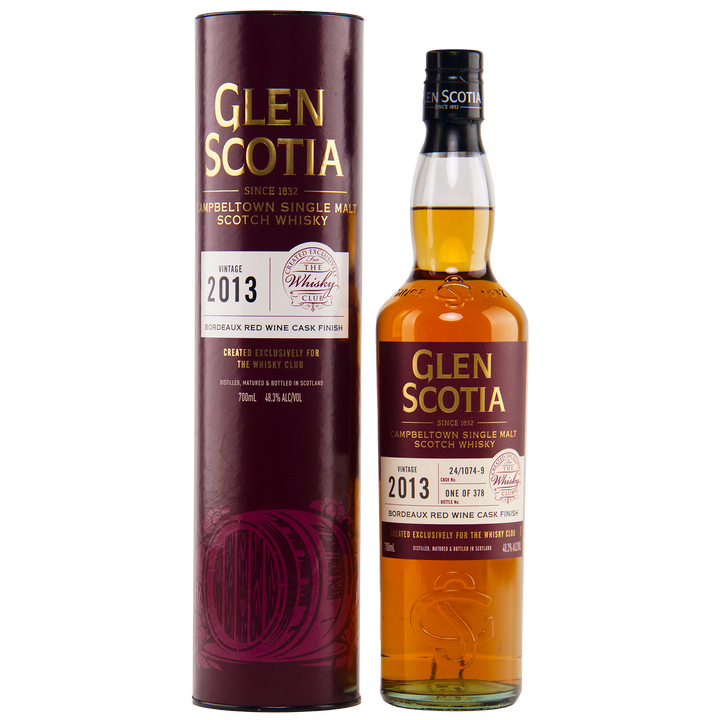 The Glen Scotia 2013 Bordeaux Single Cask bottle stands next to its maroon cylindrical packaging, both displaying gold and white text detailing its specifications, including maturation in a Bordeaux red wine cask.