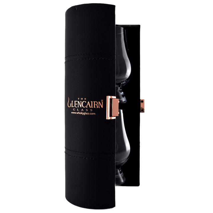 A black cylindrical travel case with gold "The Glencairn Glass" lettering and a copper latch holds two Glencairn Original Crystal Whisky Glasses—ideal for whisky tasting wherever you go.