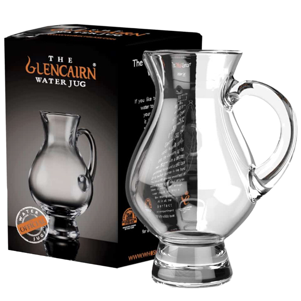 A clear Glencairn Crystal Water Jug sits beside its black box, which features an image of the jug and orange “The Glencairn Water Jug” branding—ideal for enhancing your whisky tasting experience.