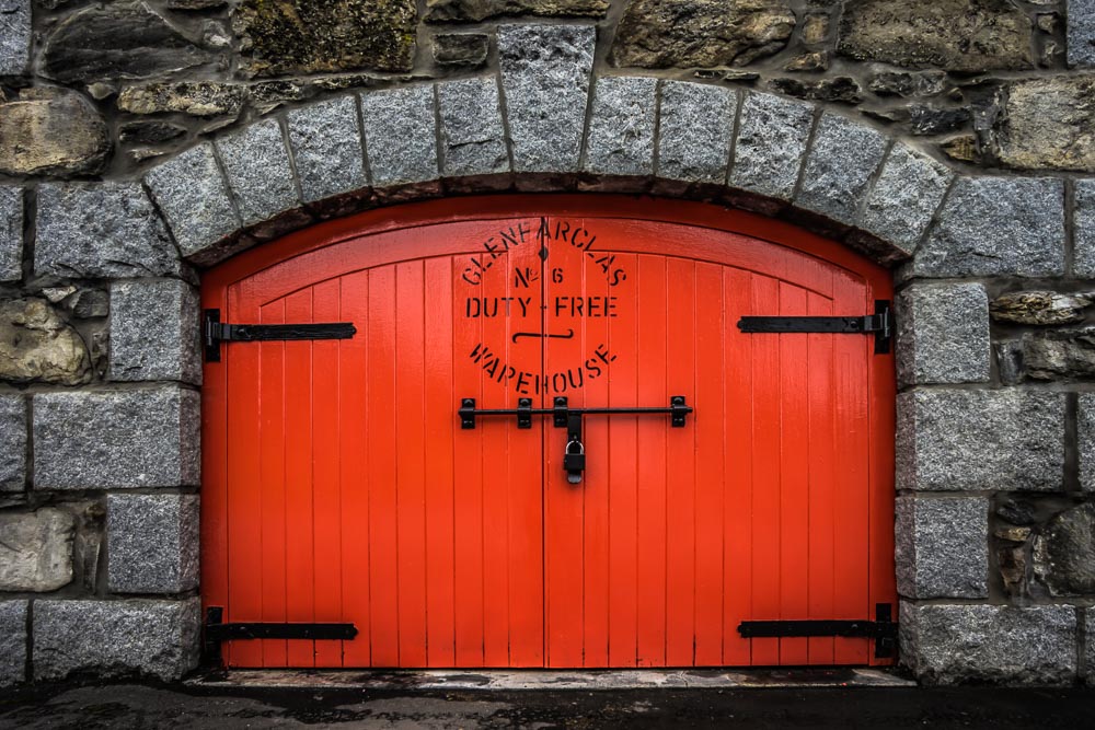 Red door with text on a stone wall