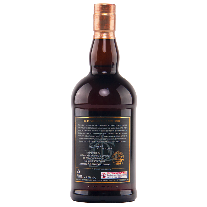 A dark brown bottle with a copper cap, shown from the back. The label has gold and white text, a signature, gold emblem, and red pregnancy warning—featuring Glenfarclas 2024 Christmas Edition Single Malt Whisky.