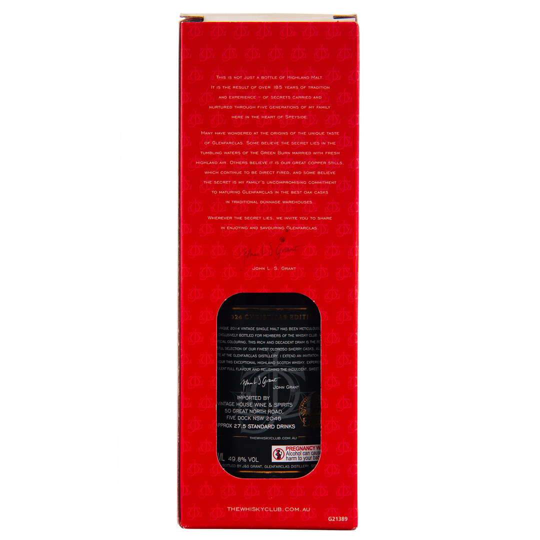 The back of a red Glenfarclas 2024 Christmas Edition Single Malt Whisky box displays gold product details, a black label with white text through a cut-out window, branding at the bottom, and repeating scale patterns on the design.