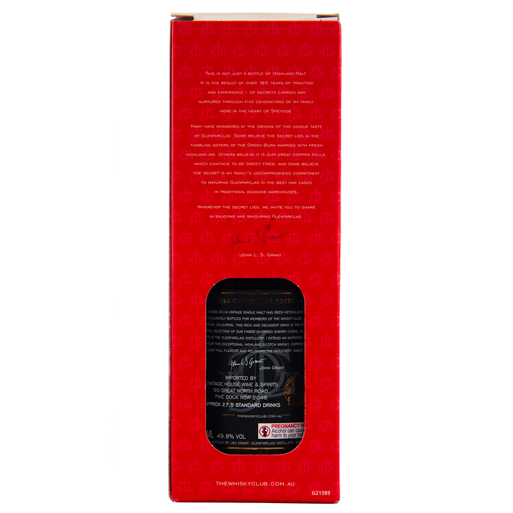 The back of a red Glenfarclas 2024 Christmas Edition Single Malt Whisky box displays gold product details, a black label with white text through a cut-out window, branding at the bottom, and repeating scale patterns on the design.