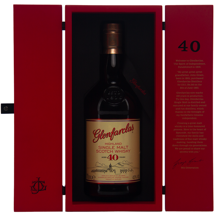 A bottle of Glenfarclas 40 year old Single Malt Scotch Whisky in an open red presentation box, with gold and red labels and gold text inside the cover detailing its rich sherried notes.