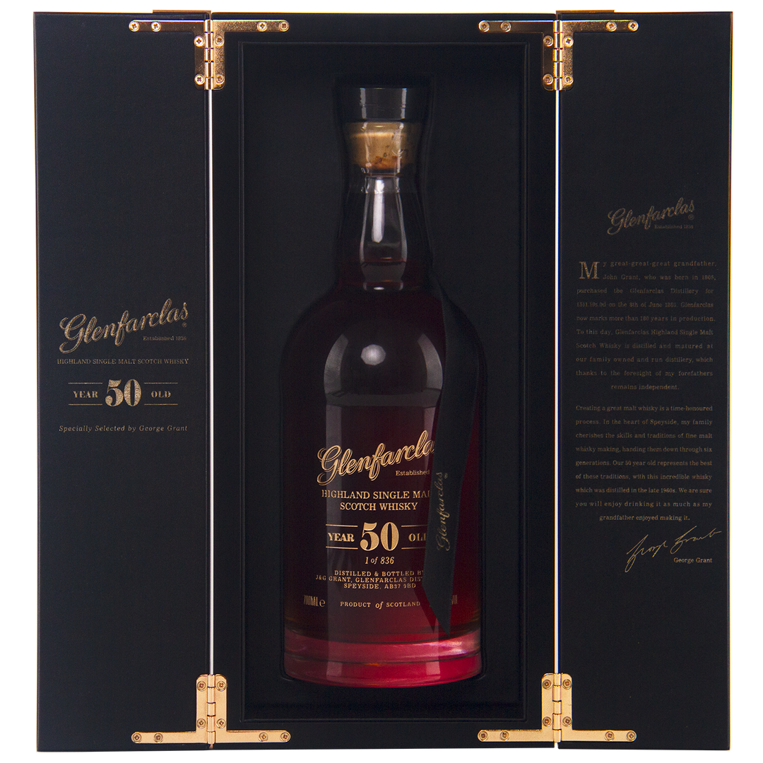 A bottle of Glenfarclas 50 Year Old Single Malt Scotch Whisky, displayed upright in an open black and gold box with gold hinges and inner text, highlighting this exceptional sherried single malt.