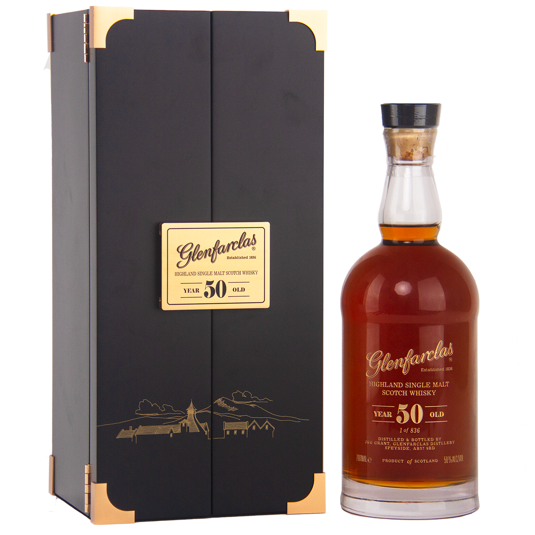 A bottle of Glenfarclas 50 Year Old Single Malt Scotch Whisky stands beside its black and gold box, both adorned with gold Glenfarclas labels—an iconic sherried single malt.