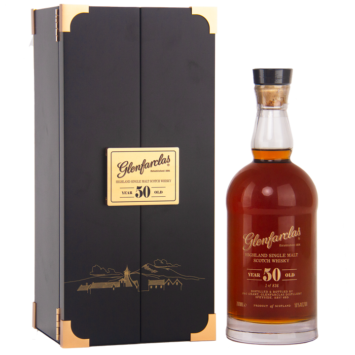 A bottle of Glenfarclas 50 Year Old Single Malt Scotch Whisky stands beside its black and gold box, both adorned with gold Glenfarclas labels—an iconic sherried single malt.