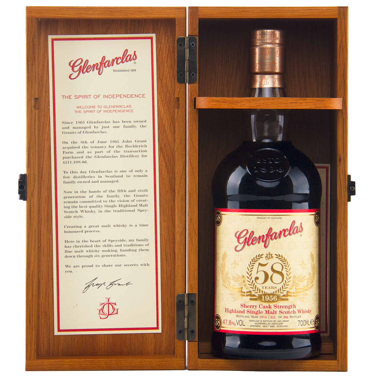 A bottle of Glenfarclas 1956 58 Year Old Sherry Cask Strength whisky is displayed in an open wooden box, with its description and history detailed on the inside of the left door.