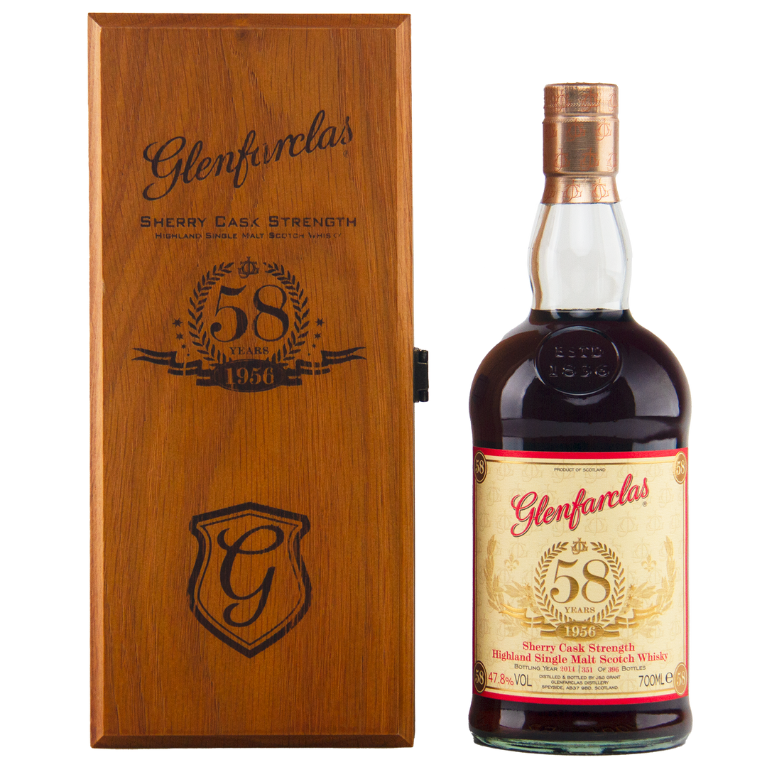 A bottle of Glenfarclas 1956 58 Year Old Sherry Cask Strength with a cream and gold label is displayed next to a wooden box engraved with the Glenfarclas logo, "58 Years," and "1956.