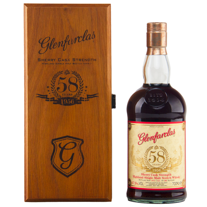 A bottle of Glenfarclas 1956 58 Year Old Sherry Cask Strength with a cream and gold label is displayed next to a wooden box engraved with the Glenfarclas logo, "58 Years," and "1956.