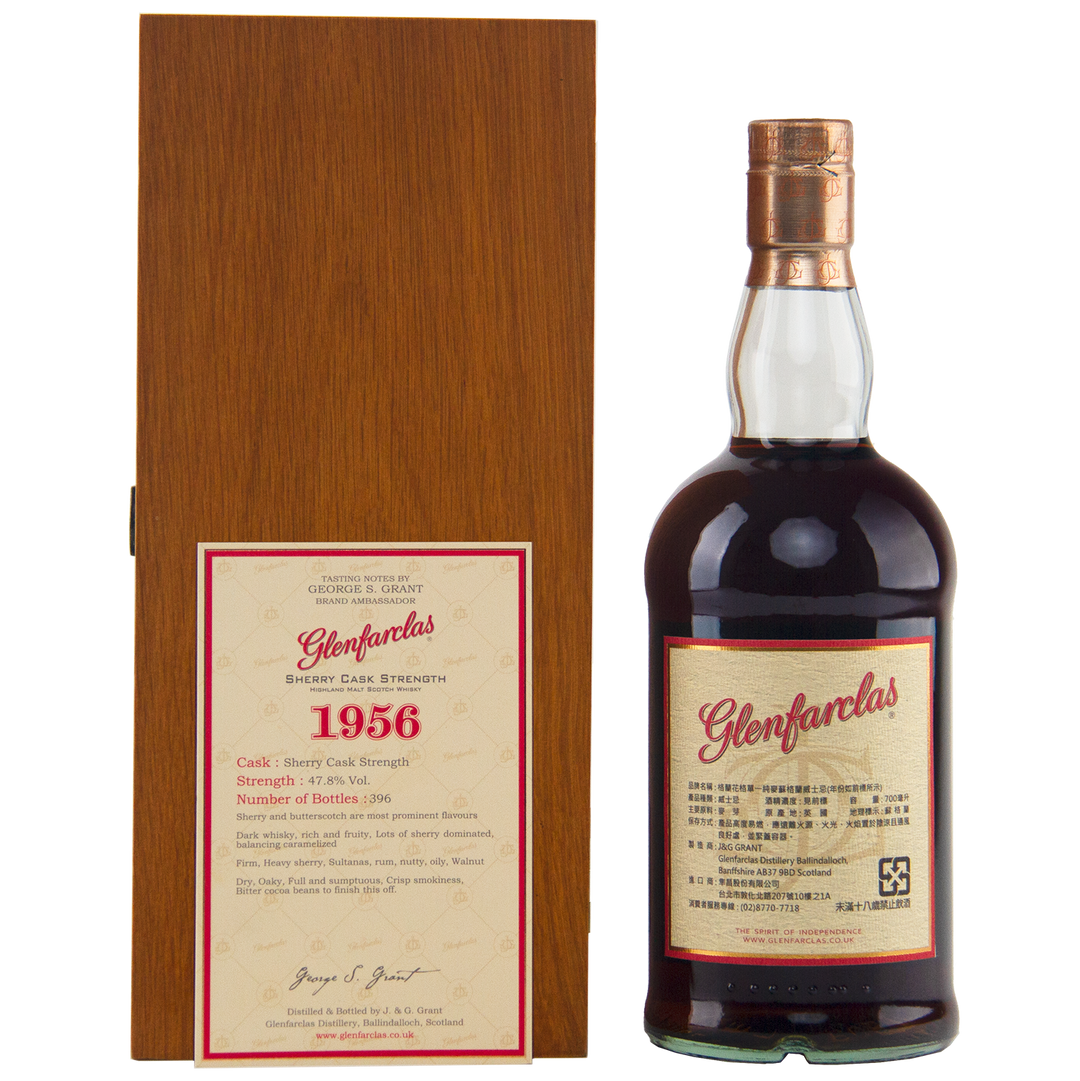 A bottle of Glenfarclas 1956 58 Year Old Sherry Cask Strength whisky is displayed beside a wooden box featuring a detailed label with its cask strength, vintage year, and limited release details.