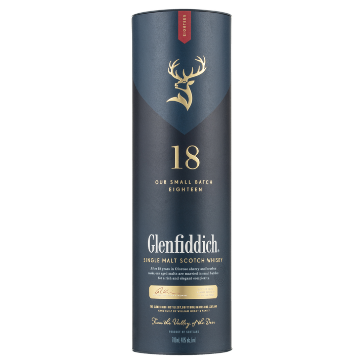 A tall, cylindrical dark blue box with gold and white lettering for Glenfiddich 18 Year Old Single Malt Scotch Whisky, featuring a gold stag logo and a red accent at the top.