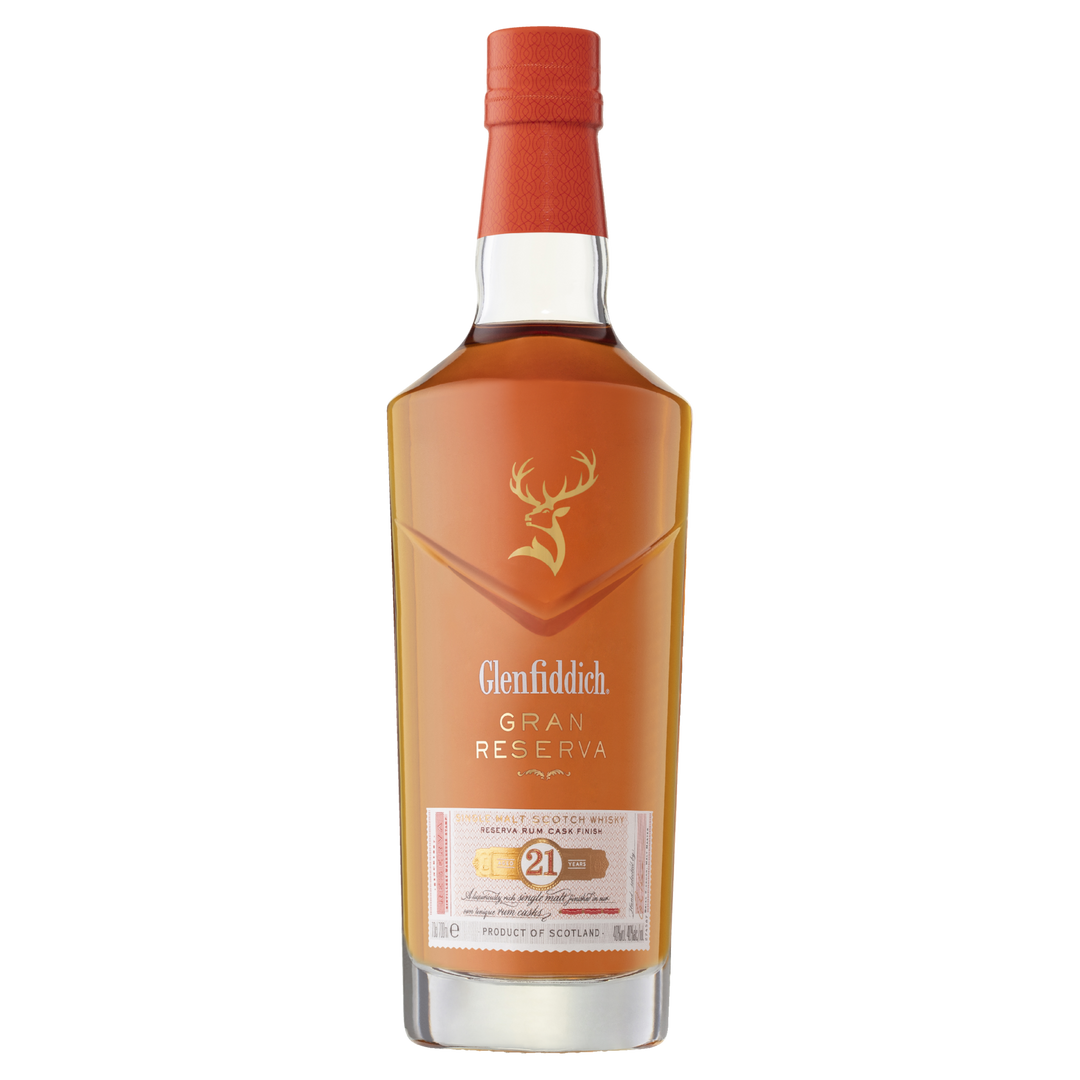 A bottle of Glenfiddich 21 Year Old Gran Reserva Single Malt Scotch Whisky, finished in Caribbean rum casks, featuring a red cap, gold stag logo, and a white-and-gold label on a clear background.