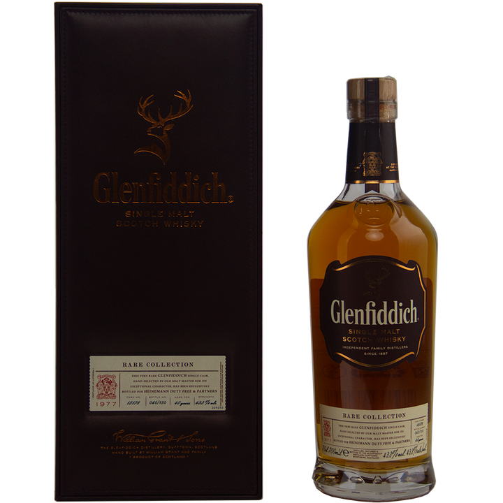 A bottle of Glenfiddich 40 Year Old 1977 Rare Vintage Single Malt Scotch Whisky stands next to its dark brown presentation box, both adorned with gold lettering and detailed labels.