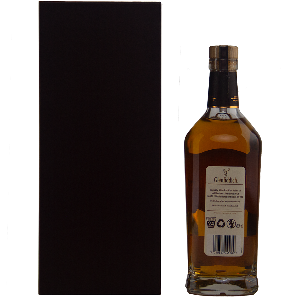 A bottle of Glenfiddich 40 year old 1977 Rare Vintage Single Malt Scotch Whisky with a gold cap stands beside a tall, plain black box. The back label shows product info and recycling symbols from this rare collection.