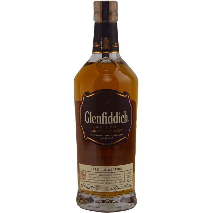 A bottle of Glenfiddich 40 Year Old 1977 Rare Vintage Single Malt Scotch Whisky, a rare single malt featuring a brown label with gold accents and rich amber whisky from a single cask.