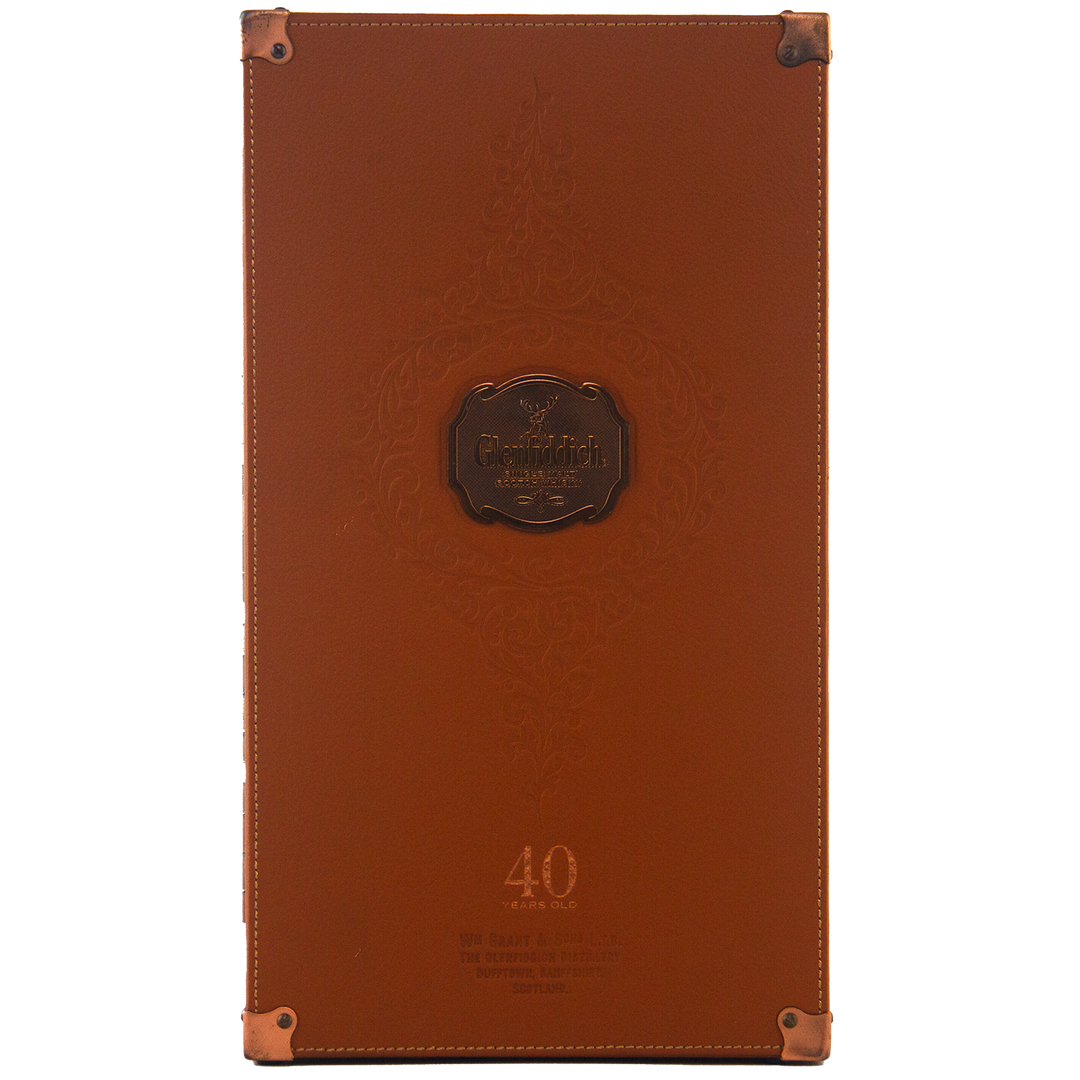 A brown leather case for Glenfiddich 40 Year Old Single Malt Scotch Whisky features embossed patterns, metal corner protectors, and "40 Years Old" at the base. The Glenfiddich logo appears at the center of this elegant limited edition box.